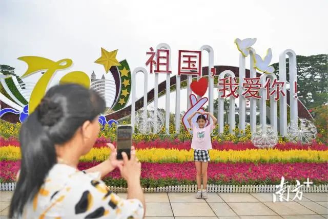 东湖广场花卉组景前,萌娃们摆出爱心动作拍照留念。 南方+ 杨兴乐 拍摄 图片