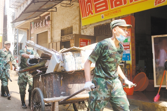 武警官兵顶着烈日参与灾后重建，展现了子弟兵本色。